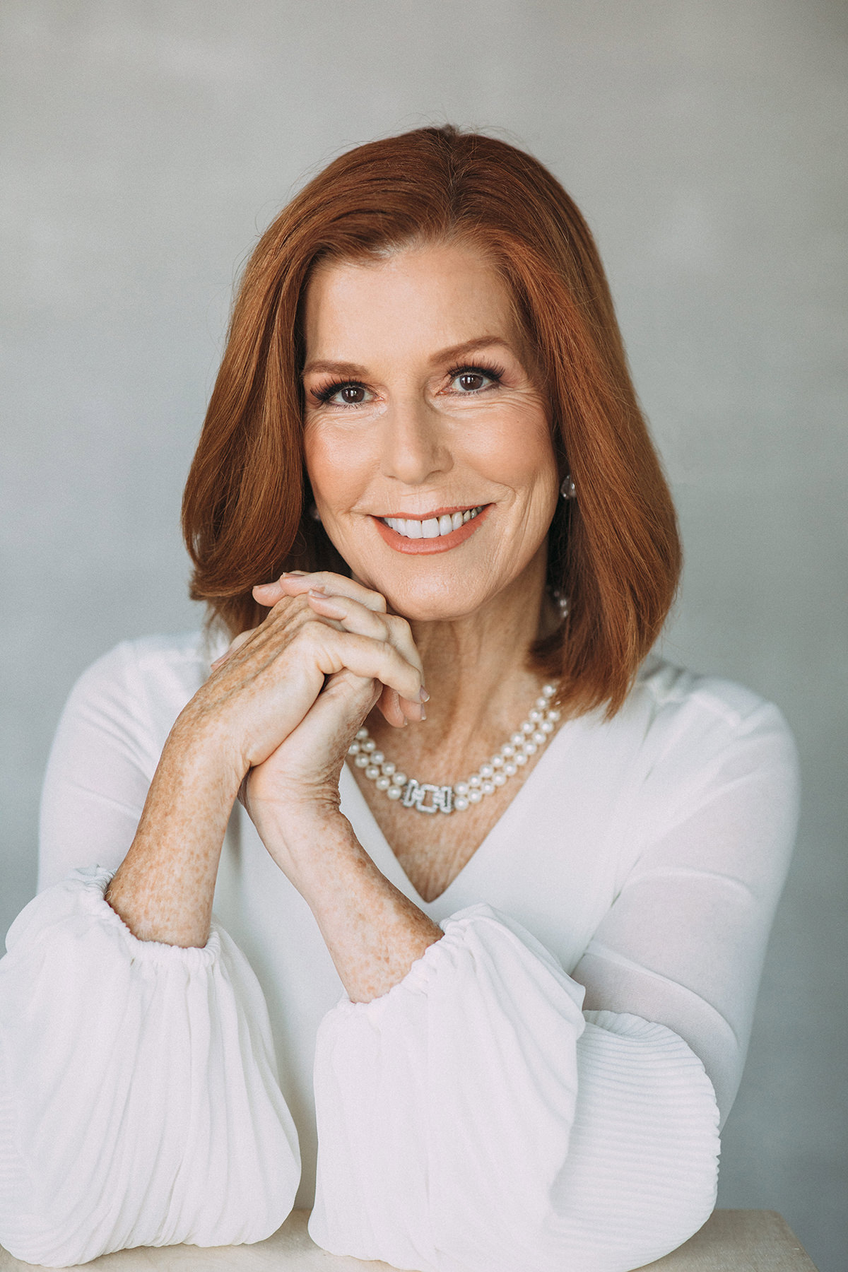 A legacy portrait of a woman wearing a white top created in a photography studio.