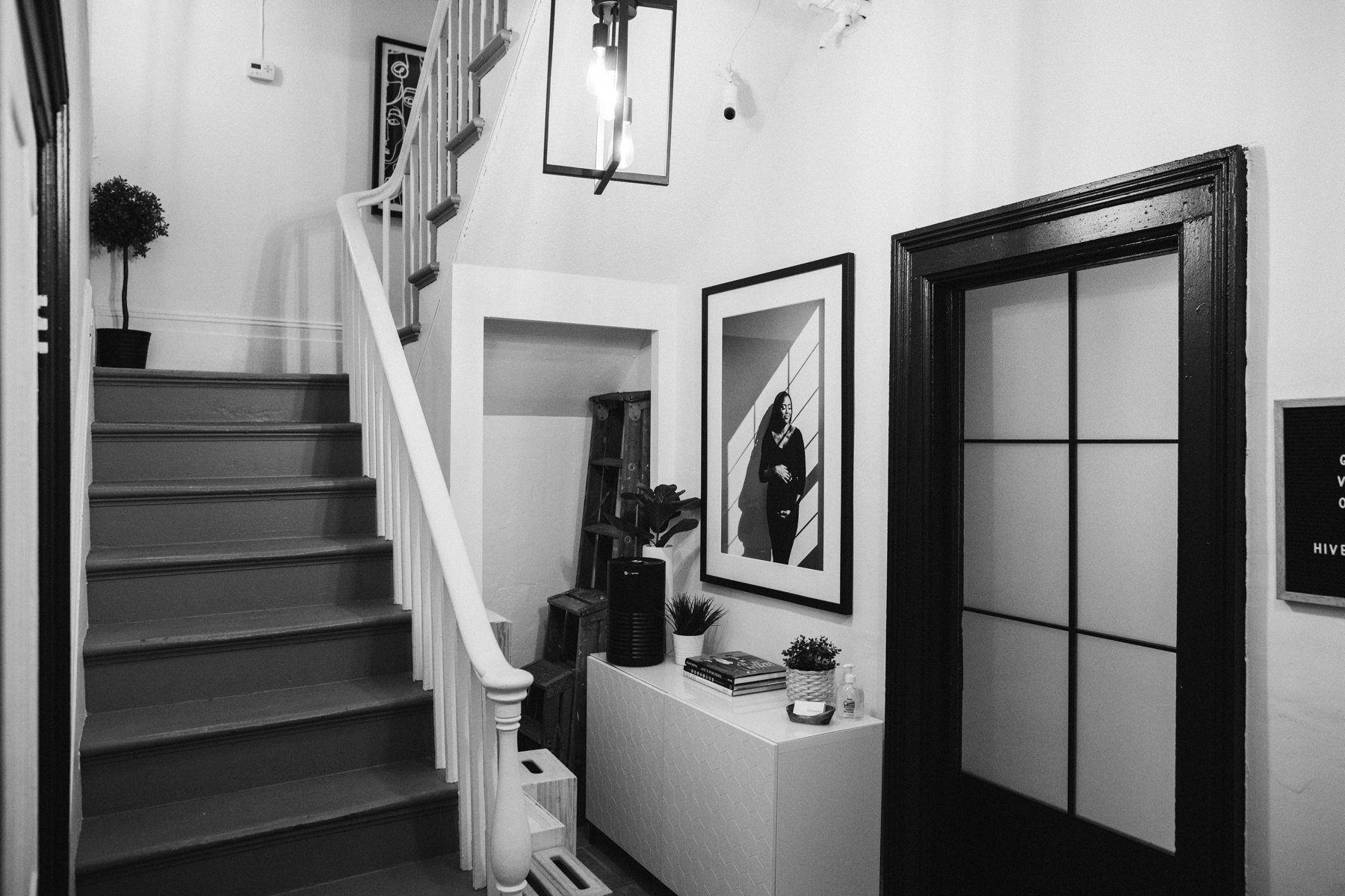 This is the lobby area with stairs and a doorway. It features some studio props and large portrait wall art on display.